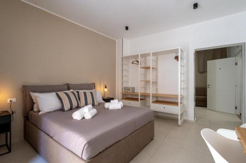 a bedroom with a bed with two stuffed animals on it at Hotel Vicolo Aperta in Trapani
