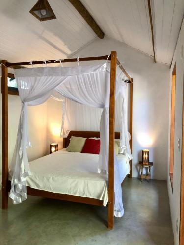 a bedroom with a bed with a canopy at Suite Jenipapo Caraiva in Caraíva