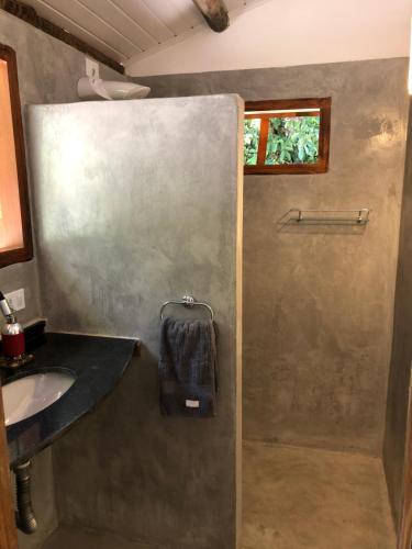 a bathroom with a shower and a sink at Suite Jenipapo Caraiva in Caraíva