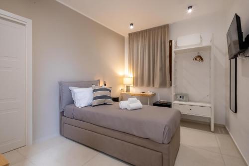 a bedroom with a bed with pillows and a television at Hotel Vicolo Aperta in Trapani