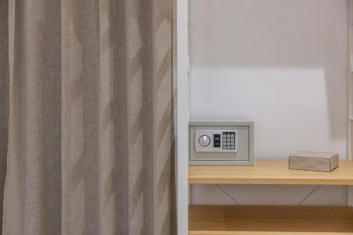 a microwave sitting on a shelf next to a curtain at Hotel Vicolo Aperta in Trapani