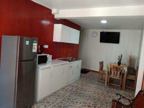 a kitchen with a refrigerator and a sink in it at Ayelen Apart Hotel in Calama