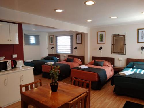 a living room with three beds and a table at Ayelen Apart Hotel in Calama