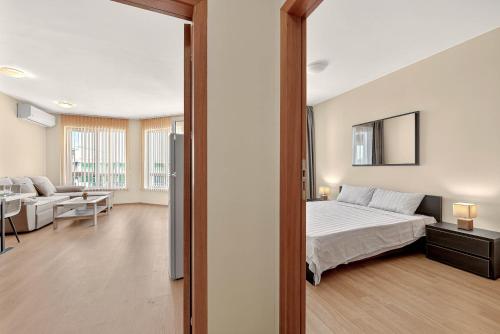 Un dormitorio con una cama y una sala de estar. en Апартамент Danili нов двустаен апартамент с басейн и паркомясто в гр Бяла, en Byala