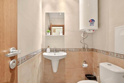 Un baño con lavabo, inodoro y espejo. en Апартамент Danili нов двустаен апартамент с басейн и паркомясто в гр Бяла, en Byala
