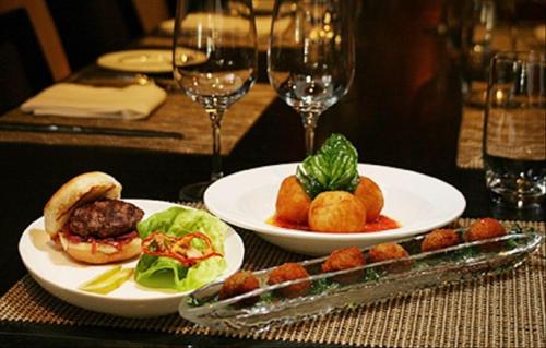 two plates of food on a table with wine glasses at SBV Luxury Ocean Hotel Suites in Miami Beach