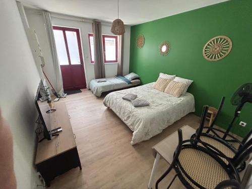 a bedroom with green walls and a bed and a table at Le Studio du Marechal in Niort