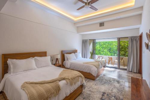 Кровать или кровати в номере Casa Playa Cozumel - Luxury Beachfront Villa