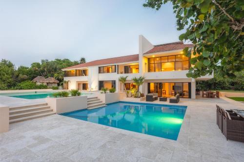a large house with a swimming pool in front of it at Casa Playa Cozumel - Luxury Beachfront Villa in Cozumel