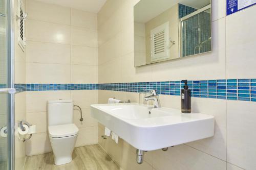 a bathroom with a sink and a toilet at Invisa Hotel Es Pla - Adults Only in San Antonio