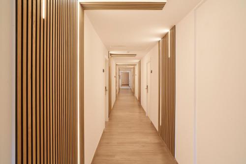 a long hallway with white walls and wooden floors at Invisa Hotel Es Pla - Adults Only in San Antonio