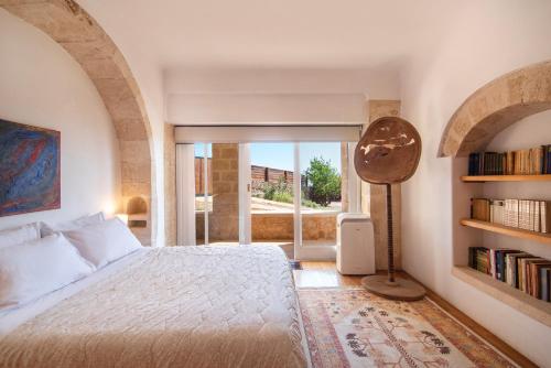 a bedroom with a bed and a book shelf at Artisan Villa Aegina in Aegina Town