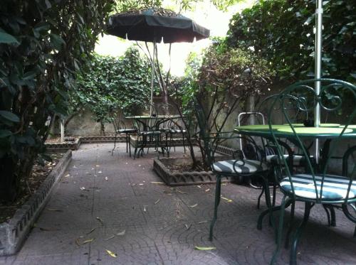 a patio with tables and chairs and an umbrella at Hotel Aspromonte in Milan