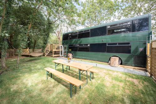 a picnic table and a bus parked in a yard at The Bus Stop, Thornham Magna in Thornham Magna
