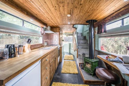 a kitchen with wooden cabinets and a wood ceiling at The Bus Stop, Thornham Magna in Thornham Magna