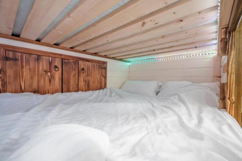 a large white bed in a wooden room at The Bus Stop, Thornham Magna in Thornham Magna
