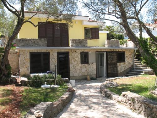 a yellow house with black shutters on it at Villa Maslina in Vantačići