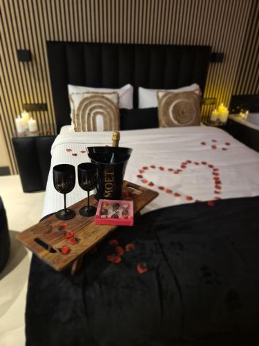 a bed with two glasses of wine and a tray of roses at Hotel Broer & Zus in The Hague