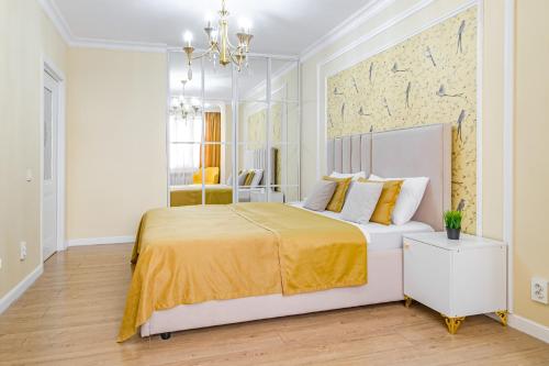 a bedroom with a large bed with a yellow blanket at Symphony Guest House in Astana