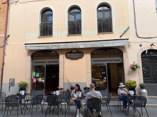 two people sitting at tables outside of a restaurant at Affittacamere Residenza Montedoro in Norcia