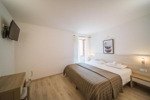 a bedroom with a bed and a desk and a television at Borgo Sereno in Motovun