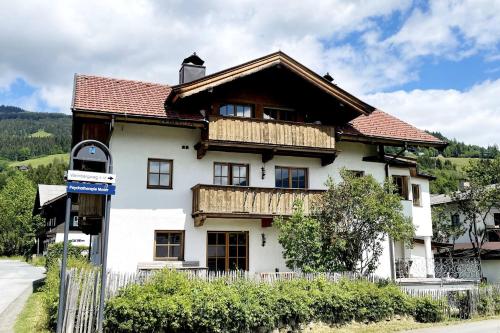 a large white house with a wooden roof at KitzAlps Apartments by Alpine Host Helpers in Kirchberg in Tirol