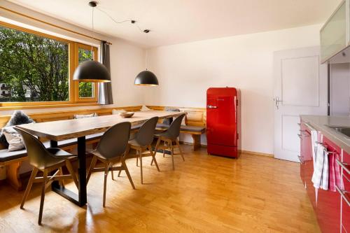 a kitchen with a table and chairs and a red refrigerator at KitzAlps Apartments by Alpine Host Helpers in Kirchberg in Tirol