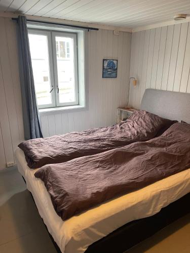 a large bed in a bedroom with a window at Sjarmerende historisk leilighet midt i Tromsø in Tromsø