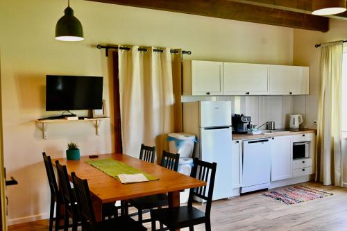 a kitchen with a table with chairs and a refrigerator at Żubrowe Sioło - dom w naturze - najładniejsze widoki - nowość in Białowieża