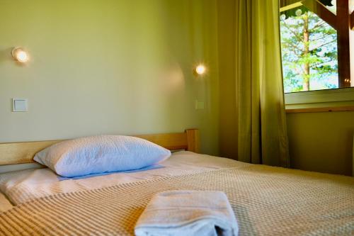 a bedroom with a bed with a pillow and a window at Żubrowe Sioło - dom w naturze - najładniejsze widoki - nowość in Białowieża