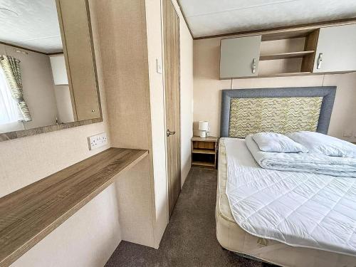 une petite chambre avec un lit et un miroir dans l'établissement Beautiful 6 Berth Caravan At Breydon Water Nearby Great Yarmouth Ref 10056B, à Belton