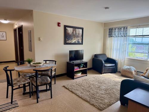 a living room with a table and a tv at Broad Street Commons in Plattsburgh