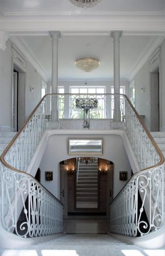 a staircase in a home with a white stair case at Palac i Loft Ojrzanów in Ojrzanów