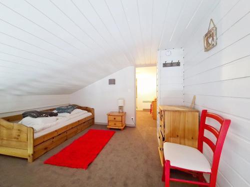 - une chambre avec un lit, une chaise et un tapis rouge dans l'établissement Fermes FMA23 COSY & MOUNTAIN 5 Pers, à Châtel