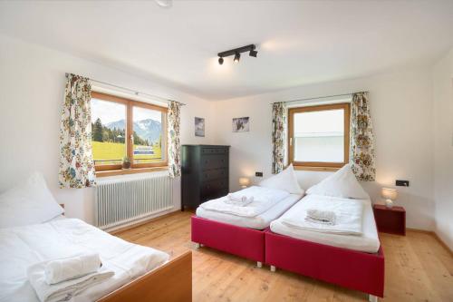 a bedroom with two beds and a window at Grand Chalet Hochfilzen in Hochfilzen