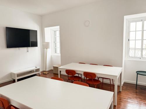 a room with two tables and a flat screen tv at Sao Pedro Guest House in Faro