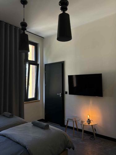 a bedroom with two beds and a flat screen tv at "Przy Rynku" pokoje z prywatnymi łazienkami in Gliwice