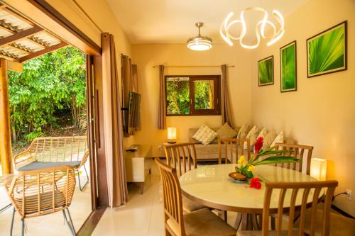 a dining room and living room with a table and chairs at Forest House Pipa in Pipa