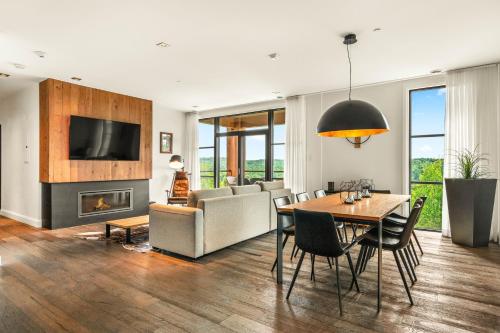 a living room with a table and a couch and a television at Tremblant Prestige - Horizon 1-104 in Mont-Tremblant