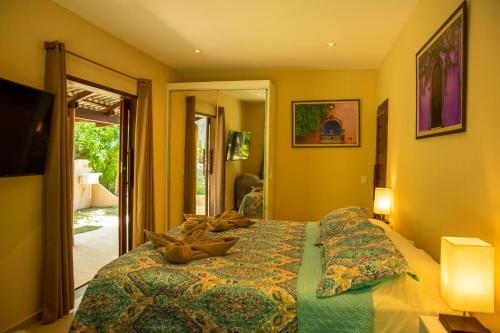 a bedroom with a bed with a green comforter at Forest House Pipa in Pipa