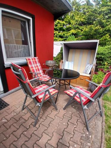 a patio with three chairs and a table and a grill at Ferienbungalow in Zirkow