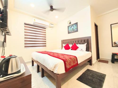 a bedroom with a large bed with red pillows at MG Park in Chennai