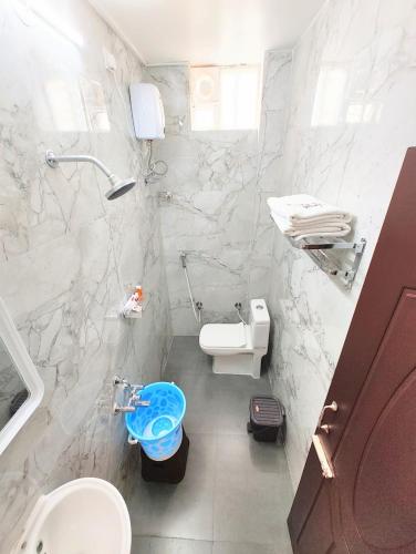 a white bathroom with a toilet and a sink at MG Park in Chennai