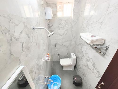 a white bathroom with a toilet and a sink at MG Park in Chennai