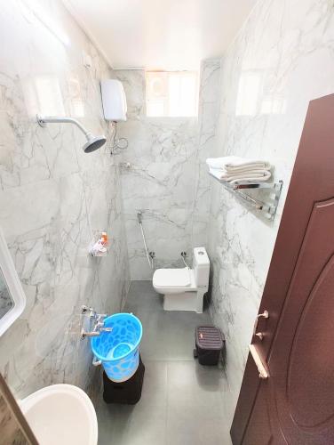 a white bathroom with a toilet and a sink at MG Park in Chennai
