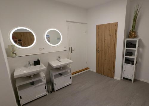 a bathroom with two sinks and two mirrors at Ferienwohnung Salzachstadt in Laufen