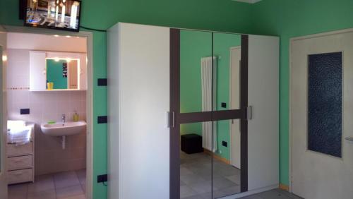 a bathroom with a glass shower door and a sink at B&B Zia Maria in Garzeno