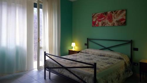 um quarto com uma cama e uma parede verde em B&B Zia Maria em Garzeno