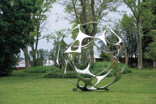 a metal sculpture in the grass in a park at San Clemente Palace Venice in Venice