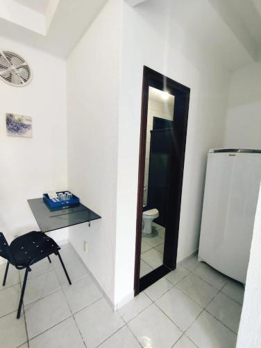 a small room with a desk and a refrigerator at Ponta Negra Suites & Apart in Natal